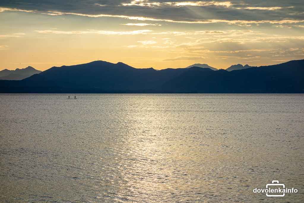 Večer pri Lago di Garda dokáže byť skutočne upokojujúci. V diaľke si ho vychutnávajú paddleboardisti.